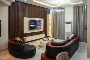 a living room with two couches and a tv at ScattHomes Lekki With Swimming Pool, PS5, Gym, Jacuzzi, Free Wifi and many more in Lekki