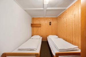 due letti in una stanza con pareti in legno di Bungalow 36a - Kimbucht a Reichendorf