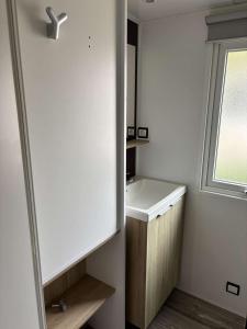 a bathroom with a sink and a window at CAMPING 4 etoiles 3 Chambres in Mimizan-Plage