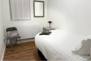 a bedroom with a bed and a chair and a mirror at Seaside Haven Retreat in South Shields in South Shields