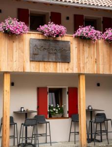 Un restaurante con mesas, sillas y flores en un edificio. en Locanda Valmorel, en Navenze