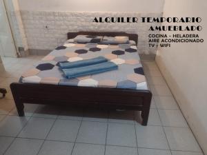 Bett mit blauen Kissen auf einem Zimmer in der Unterkunft la Cruz 1 in Formosa