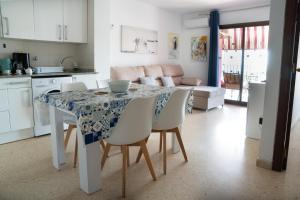 una cucina e una sala da pranzo con tavolo e sedie di Ático con vistas a Port Saplaya