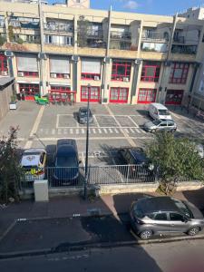 a parking lot with cars parked in front of a building at Appartement in Montreuil