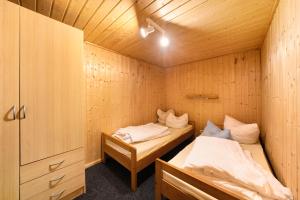 a room with two beds in a wooden cabin at Bungalow 37b - Kimbucht in Reichendorf
