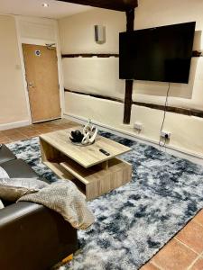 a living room with a flat screen tv on the wall at 5 bedroom House in Buckingham