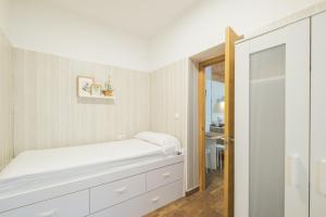 a white bedroom with a bed and a mirror at Geminis in Rota