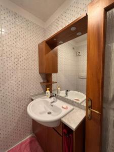 une salle de bain avec un lavabo et un miroir dans l'établissement Cottage Deluxe - nel cuore di Asiago, à Asiago