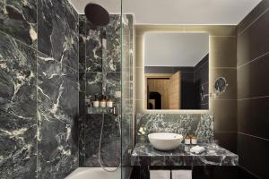 a bathroom with a sink and a shower with a mirror at Tivoli President Milano Hotel in Milan