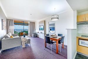 a living room with a couch and a table at Esplanade Poolside Living with Lush Balcony Vistas in Darwin