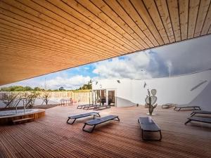a large wooden deck with benches and a large boat at Les libellules in Lanvallay