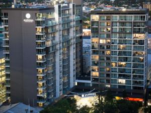 an aerial view of two tall buildings at night at Pullman Adelaide in Adelaide
