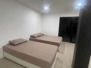 2 letti in una camera con TV a schermo piatto di Banchasramanora resort a Ban Nua
