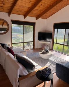 Una sala de estar con un sofá y un televisor. en Happy Valley Haven, en Sunset Strip
