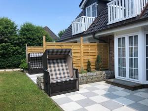 einen Stuhl auf einer Terrasse vor einem Haus in der Unterkunft Ferienhaus Berta in Süderende