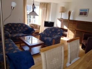 ein Wohnzimmer mit Sofa, Stühlen und einem Tisch in der Unterkunft Ferienhaus Berta in Süderende
