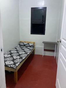 een kleine kamer met een bed en een flatscreen-tv bij Puzon-M Bed Space Kidapawan in Kidapawan