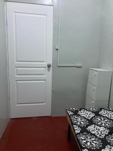 een kamer met een deur, een bed en een spiegel bij Puzon-M Bed Space Kidapawan in Kidapawan