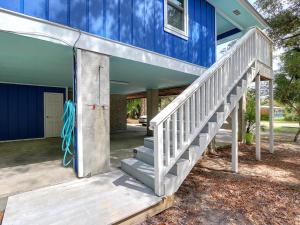 Una casa azul con escaleras que conducen a la puerta principal. en Deja Blue B, en Tybee Island