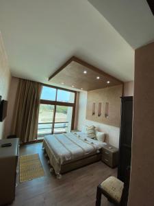 a bedroom with a bed and a large window at Nomad Hotel Tamraghet in Aourir