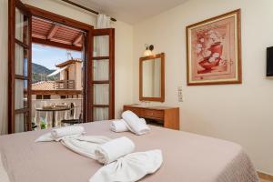 a bedroom with a bed with towels on it at Hotel Athena in Kokkari