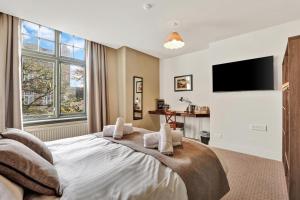 a bedroom with a large bed with a flat screen tv at The Lambton in Durham