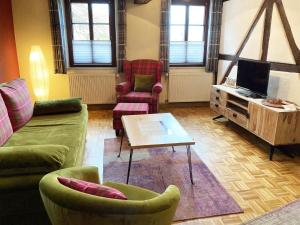 a living room with a couch and chairs and a table at Hofschänke in Winden