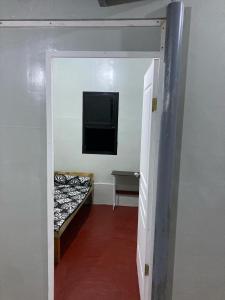 een gang met een tv en een bed in een kamer bij Puzon-M Bed Space Kidapawan in Kidapawan