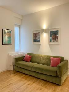 una sala de estar con un sofá verde en una habitación en Plinio 72 Apartment, en Milán