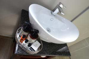 lavabo en el baño con botellas de vino en la barra en Abella Bed and Breakfast, en Vryburg
