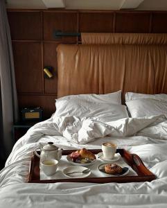 a tray of food on a bed with two cups of coffee at ROYAL SAVOY lUXURY CAMP in Wadi Rum +9 photos