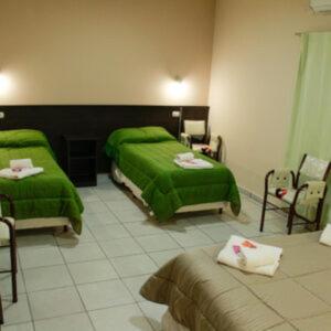 a bedroom with two green beds and chairs at Cuesta de Miranda 2 in Villa Unión +18 photos