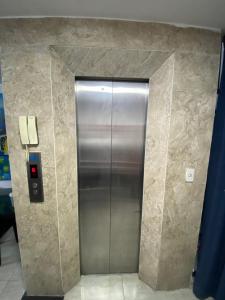 a metal elevator in a building with a wall at FUNNY Hostel & cafe in Ho Chi Minh City +5 photos