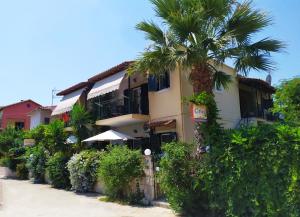 a palm tree in front of a building at Grivas Apartments in Sivota
