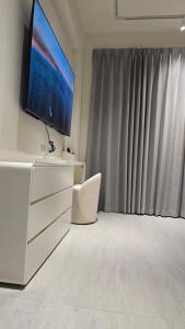a living room with a tv and a white dresser at C House 角屋 in Hsinchu City +8 photos