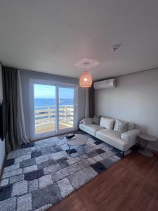 a living room with a couch and a large window at Hong Yang in Jeju