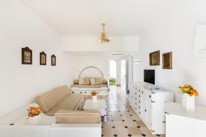 a white living room with a couch and a tv at Ostuni a Mare in Ostuni
