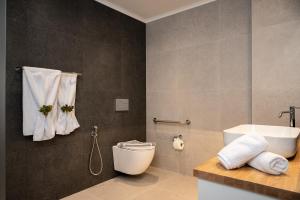 a bathroom with a toilet and a sink and a tub at Hotel Athena in Kokkari +16 photos