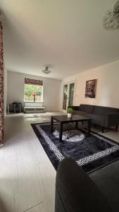 ein Wohnzimmer mit Sofa und Tisch in der Unterkunft Holiday retreat next to nature in Corby and Weldon