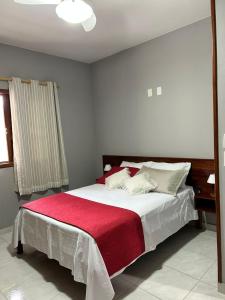 een slaapkamer met een groot bed met een rode deken bij CASA 97 completa! Horário Flexível! in Santa Teresa