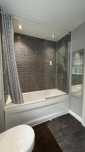 ein Badezimmer mit Badewanne und Toilette in der Unterkunft Holiday retreat next to nature in Corby and Weldon