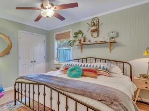 a bedroom with a bed with a ceiling fan at Salt Palms Cottage in Tybee Island +29 photos
