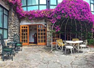 
a patio area with a table and chairs with flowers in front of it at El Ancla in Laredo
