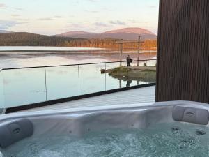 a bath tub with a view of a body of water at Joiku Luxury Lakeview Chalet in Kolari