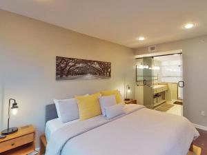 a bedroom with a large white bed with yellow pillows at Drayton Escape in Savannah +26 photos