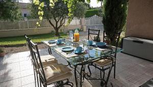 a glass table and chairs on a patio at Villa hortensia in Carpentras