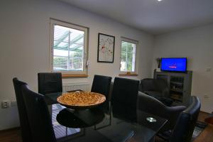 a living room with a table and chairs and a television at Domek Markoušovice in Velké Svatoňovice +6 photos