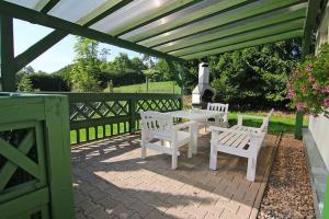 a patio with a white table and two white benches at Domek Markoušovice in Velké Svatoňovice