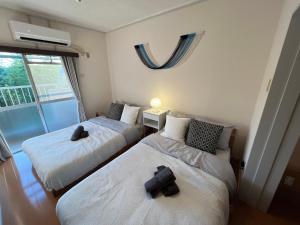 Ένα ή περισσότερα κρεβάτια σε δωμάτιο στο 伊勢ヒルトップ アパートメント