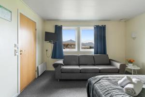a bedroom with a bed and a couch and a window at Yttersia Base in Senja